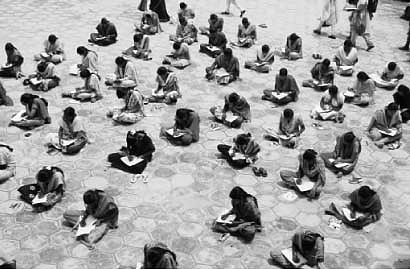 தரையில் அமர்ந்து படிக்கும் மாணவிகள்